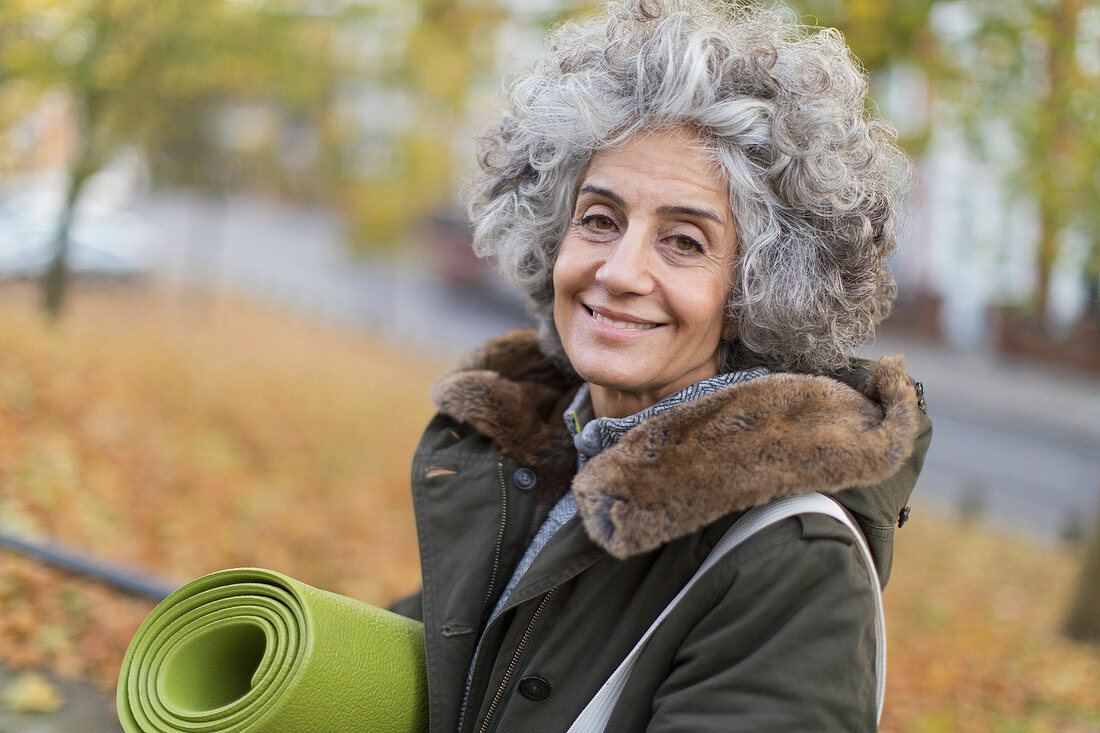 Portrait smiling, active senior woman with yoga mat