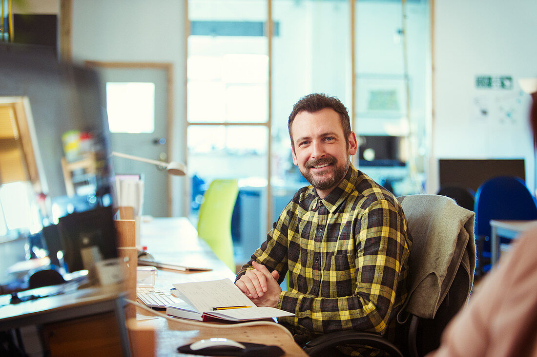 Portrait smiling creative businessman working in office