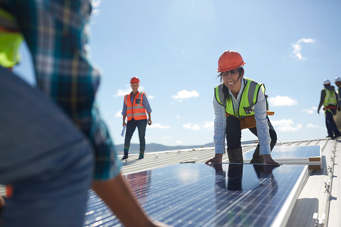 Engineers lifting solar panel at sunny power plant