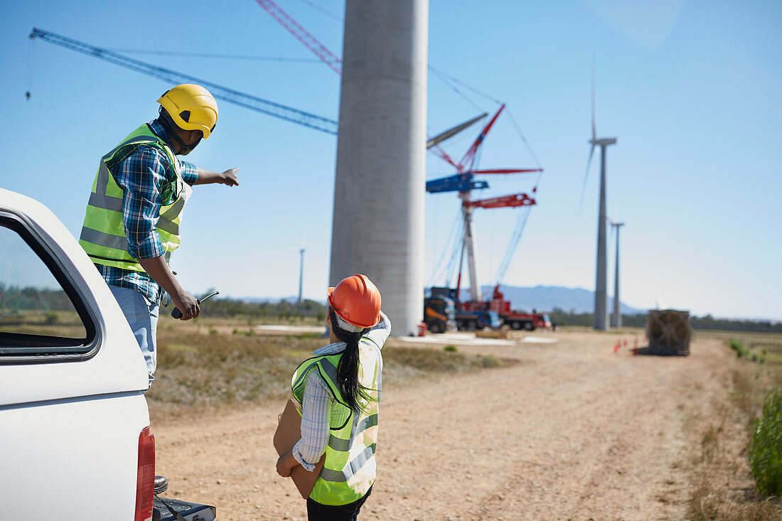 Engineers on dirt road at wind turbine power plant