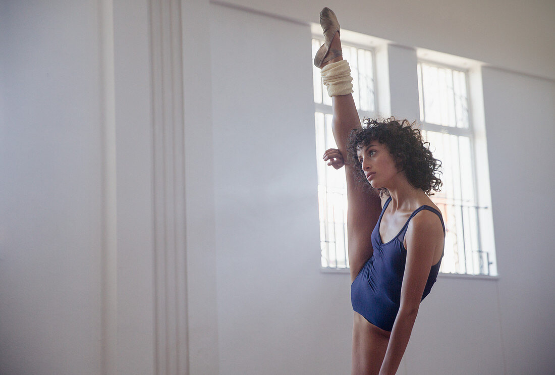 Flexible young female dancer stretching leg