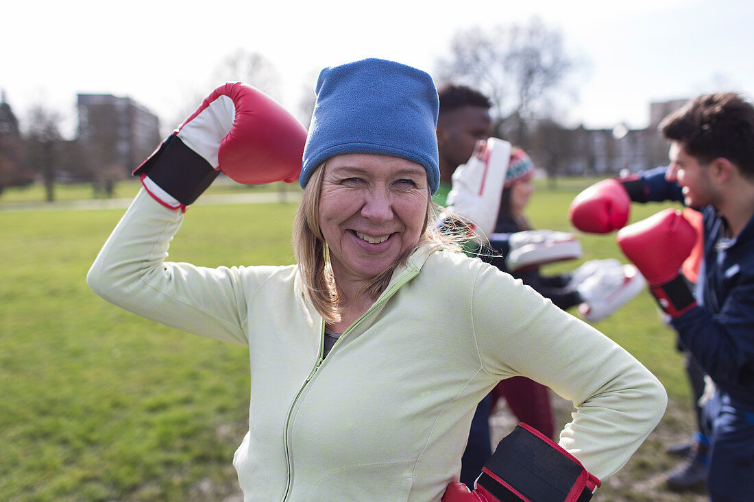 Portrait smiling senior woman boxing in park
