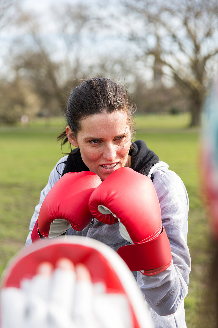 Focused, determined woman boxing in park