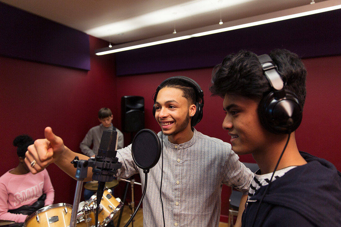Smiling teenage musicians recording music