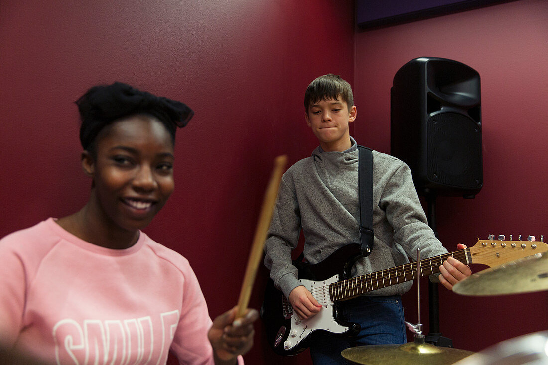 Smiling teenage musicians recording music