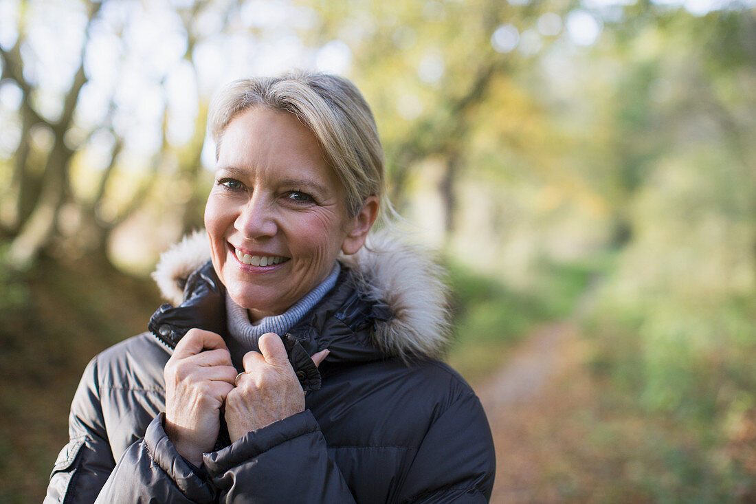 Portrait mature woman in parka in woods