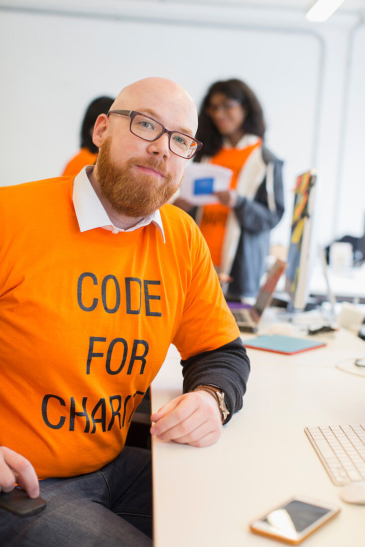 Portrait hacker coding for charity at hackathon