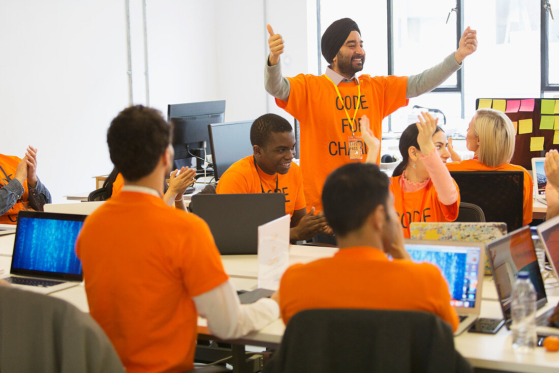 Hackers cheering, coding for charity at hackathon