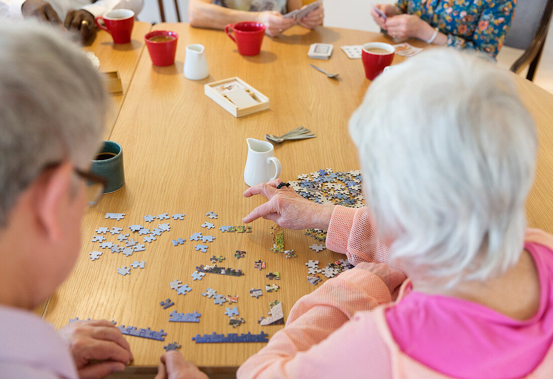 Senior friends assembling jigsaw puzzle