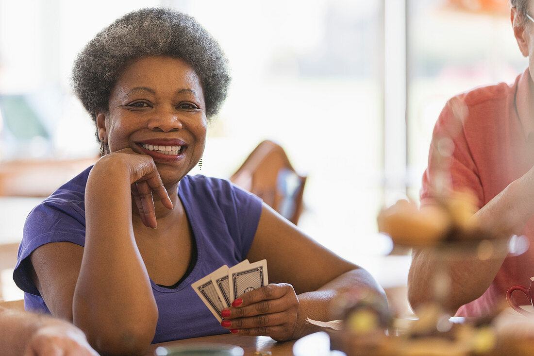 Portrait smiling, senior woman playing cards