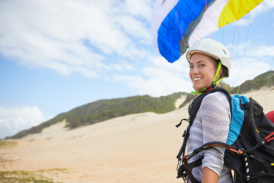 Portrait smiling, young female paraglider on beach