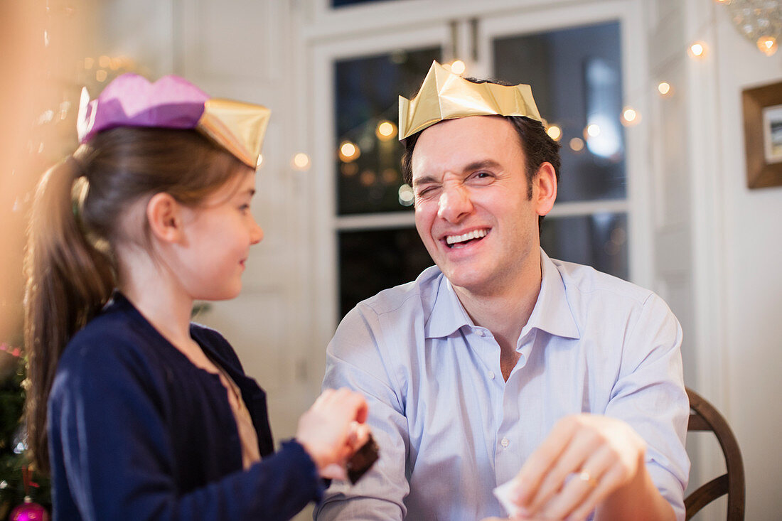 Father and daughter in paper Christmas crowns