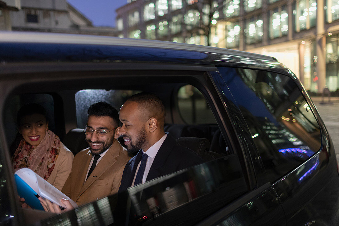 Business people in crowdsourced taxi at night