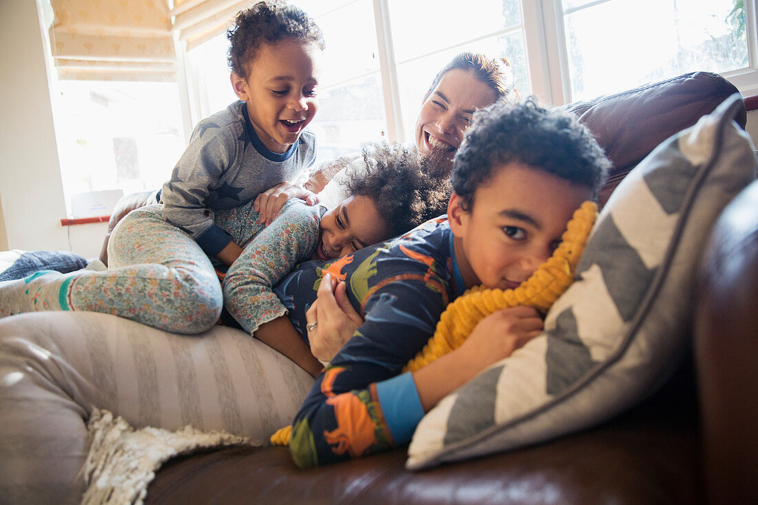 Mother and children cuddling on sofa