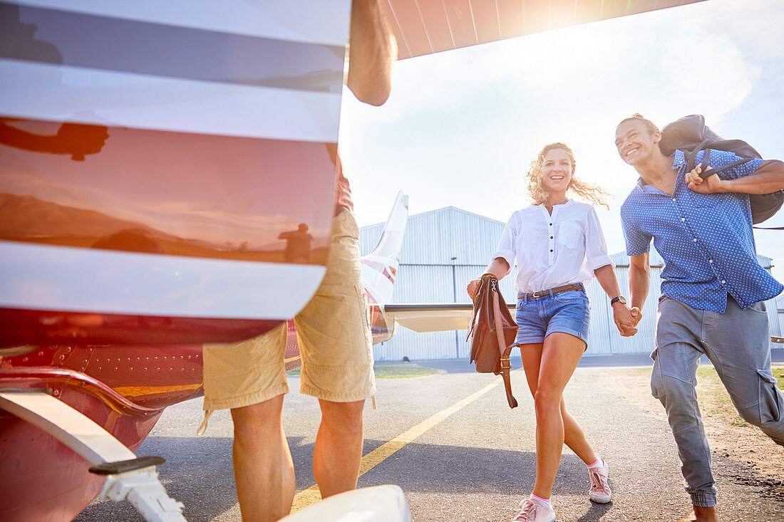 Happy, eager couple boarding small airplane