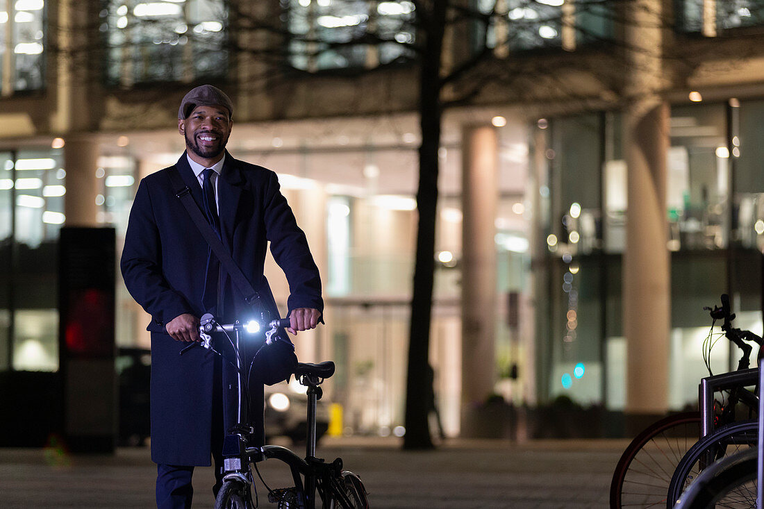 Portrait businessman with bicycle at night