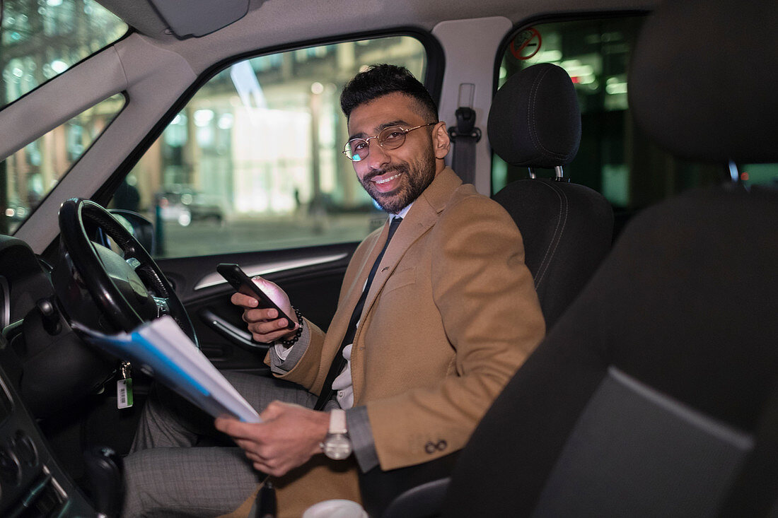 Portrait businessman reading paperwork in car