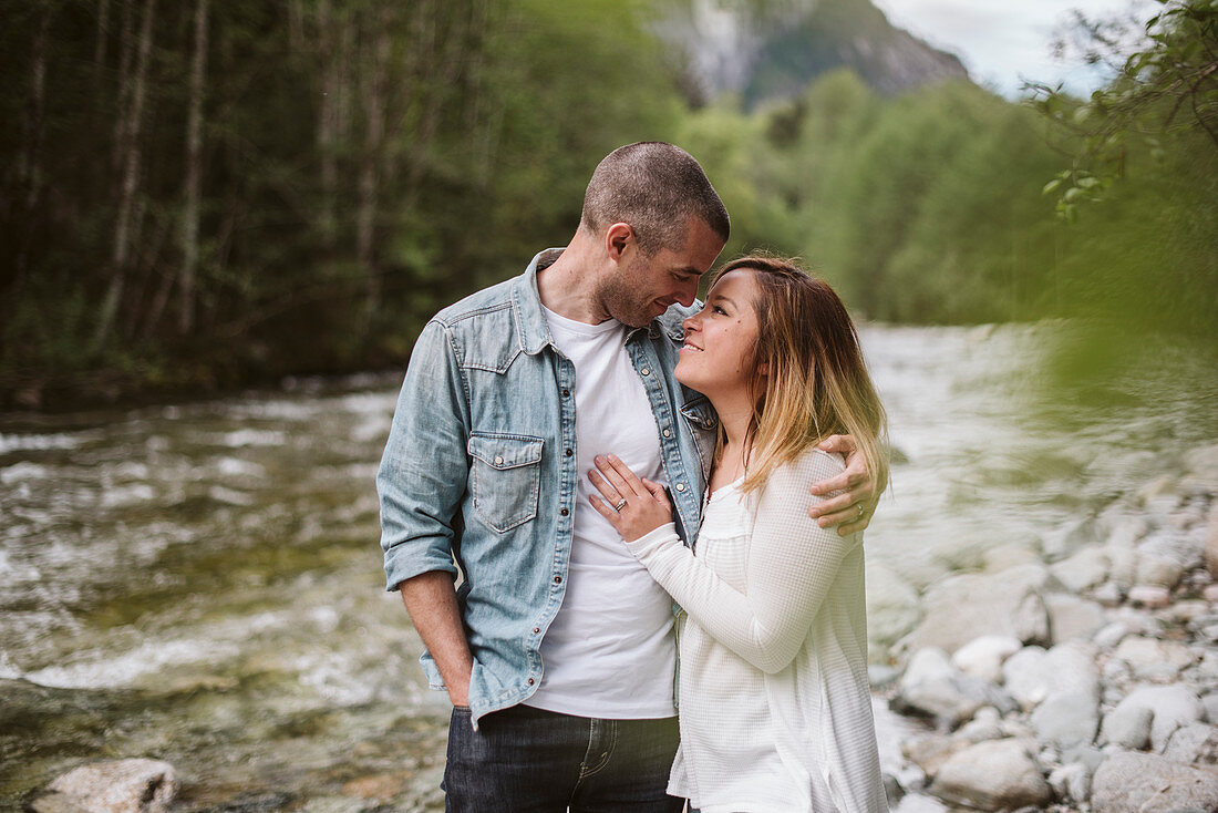 Affectionate couple hugging at riverside