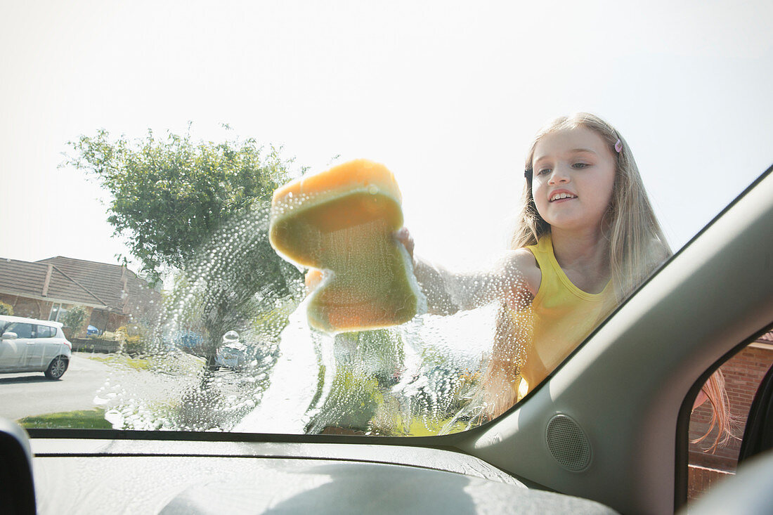 Girl washing car windshield
