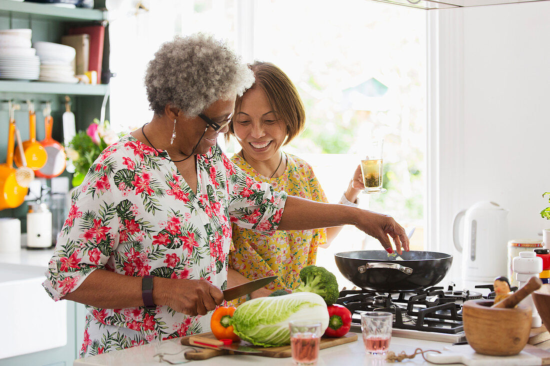 Active senior women cooking in kitchen