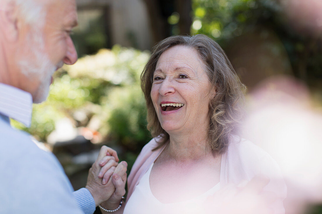 Happy, affectionate senior couple in garden