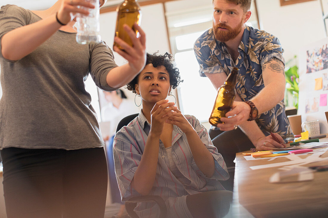 Creative designers examining bottles in office