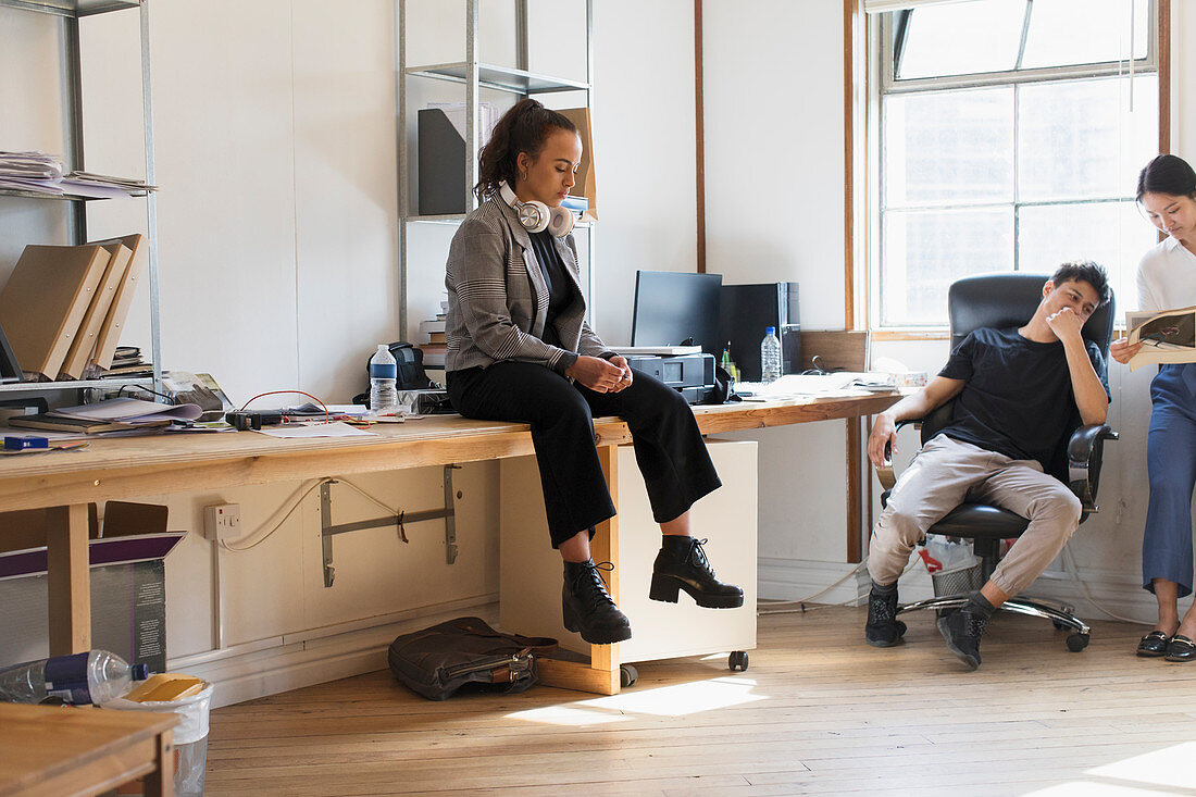 Creative businesswoman sitting on desk