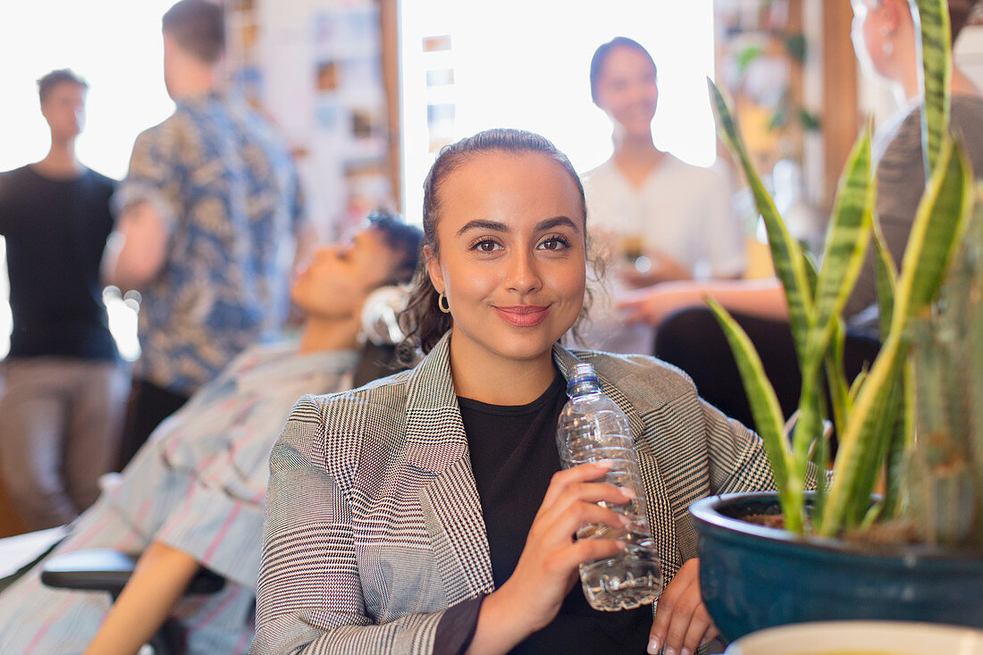 Portrait businesswoman drinking bottled water