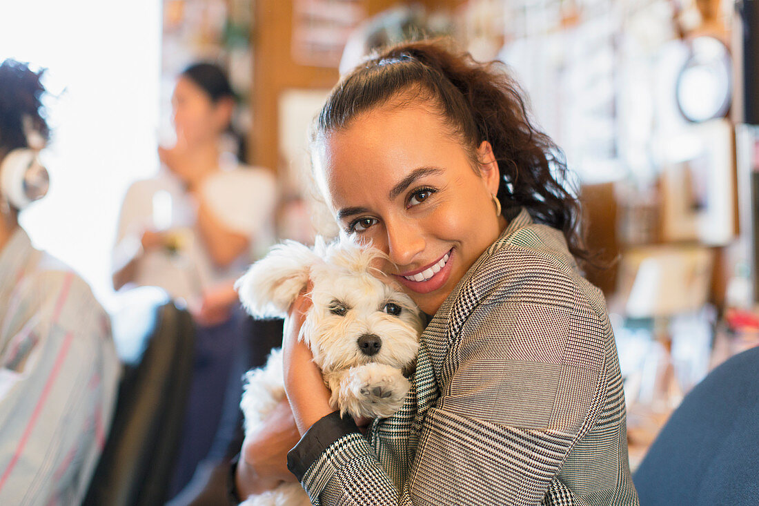 Portrait businesswoman with cute dog in office