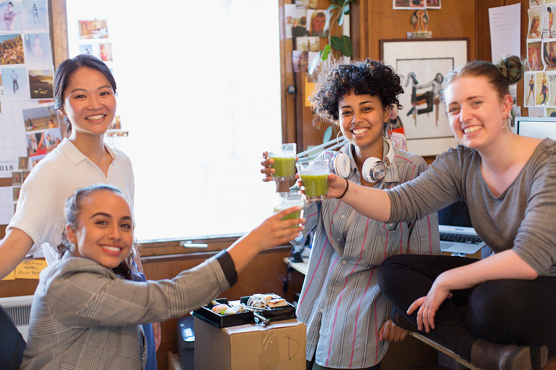 Female designers drinking green smoothies