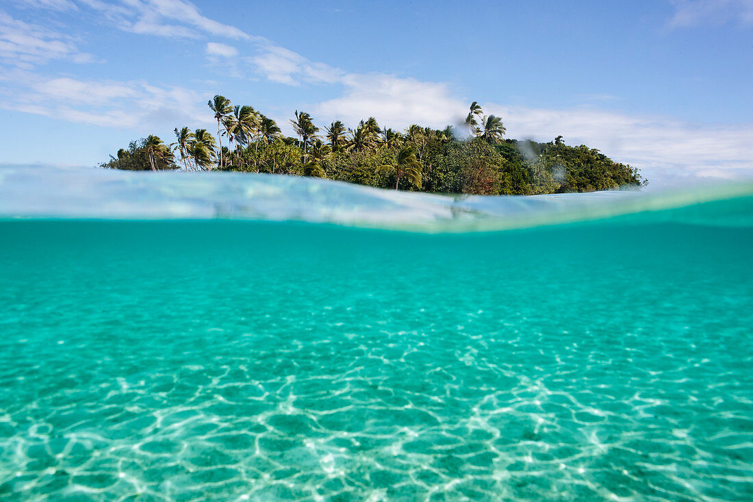 Tropical island beyond idyllic blue ocean water