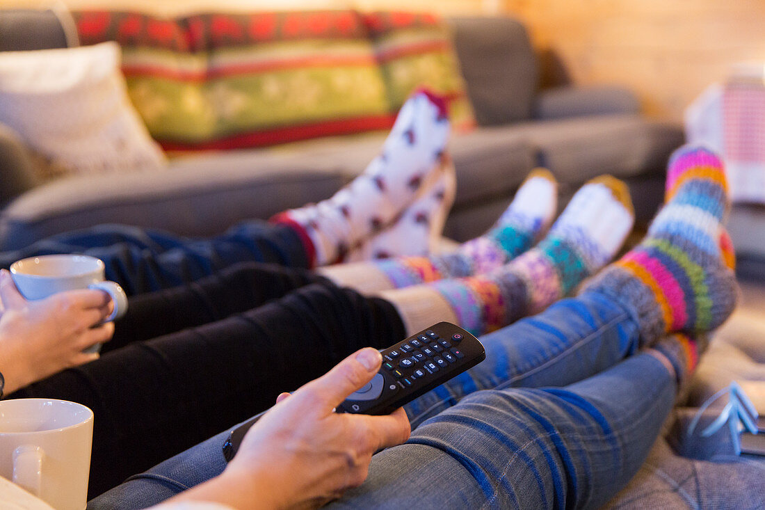 Family in colourful socks relaxing, watching TV