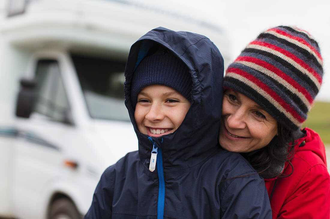 Mother and son hugging outside motor home