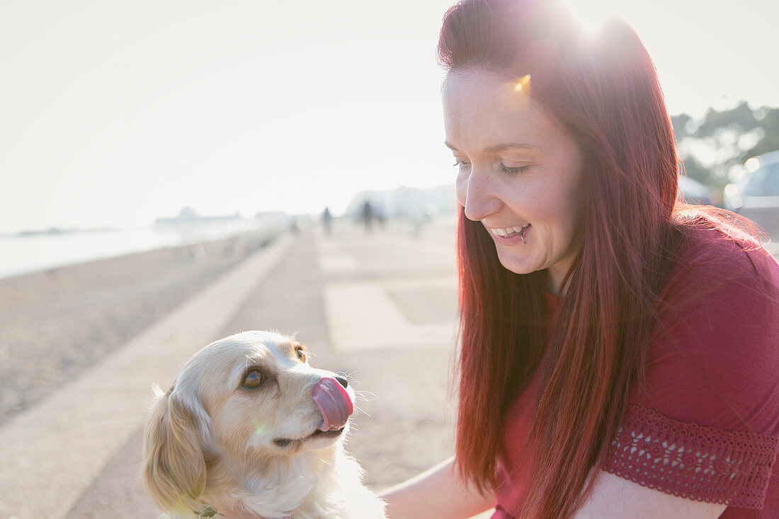 Woman with cute dog on beach boardwalk