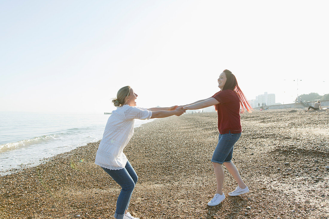 Playful lesbian couple holding hands and spinning