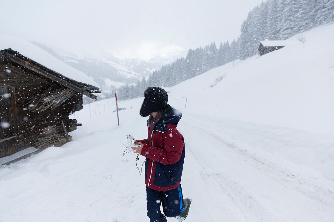 Teenage boy walking outside snowy mountain cabin