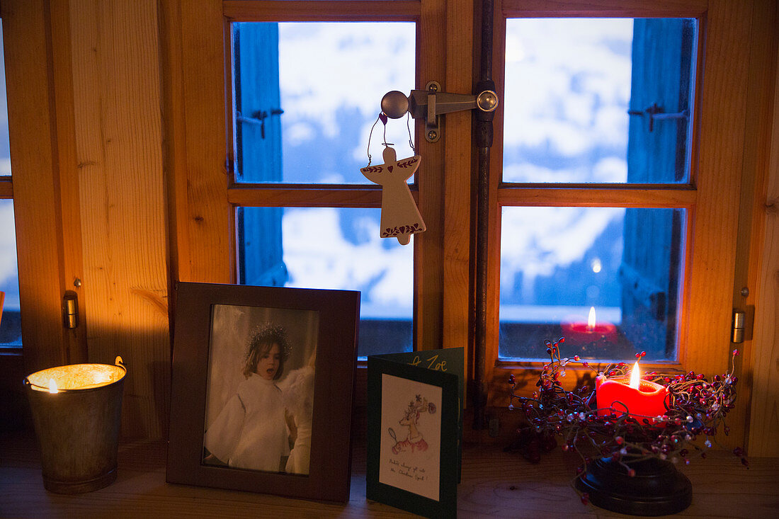 Christmas decorations and candle on windowsill