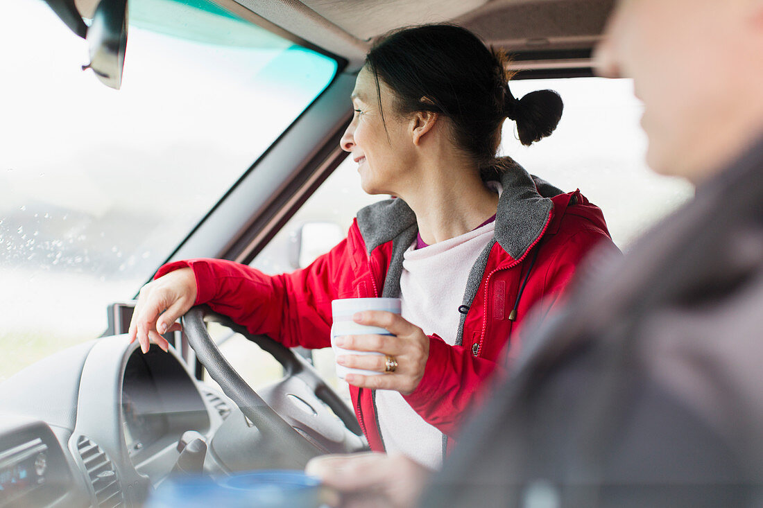 Woman with coffee driving motor home