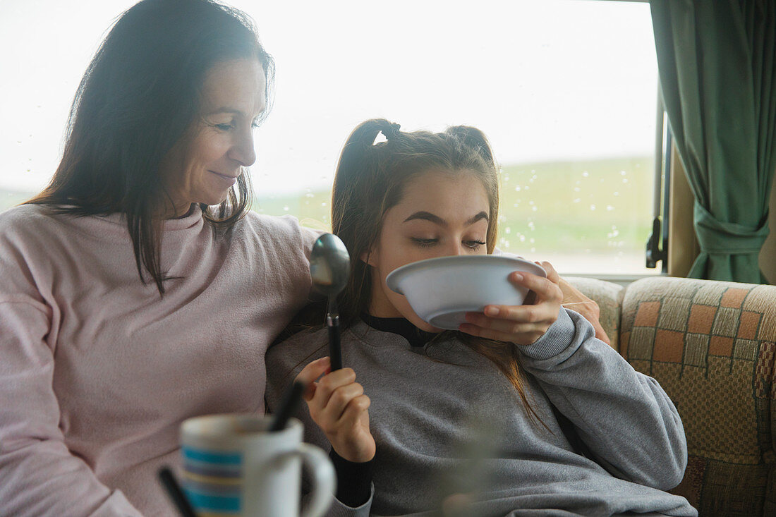 Mother watching daughter eating in motor home