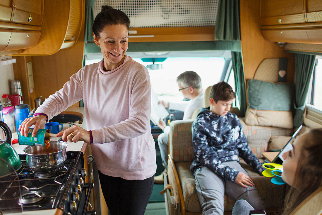 Happy family cooking and relaxing in motor home