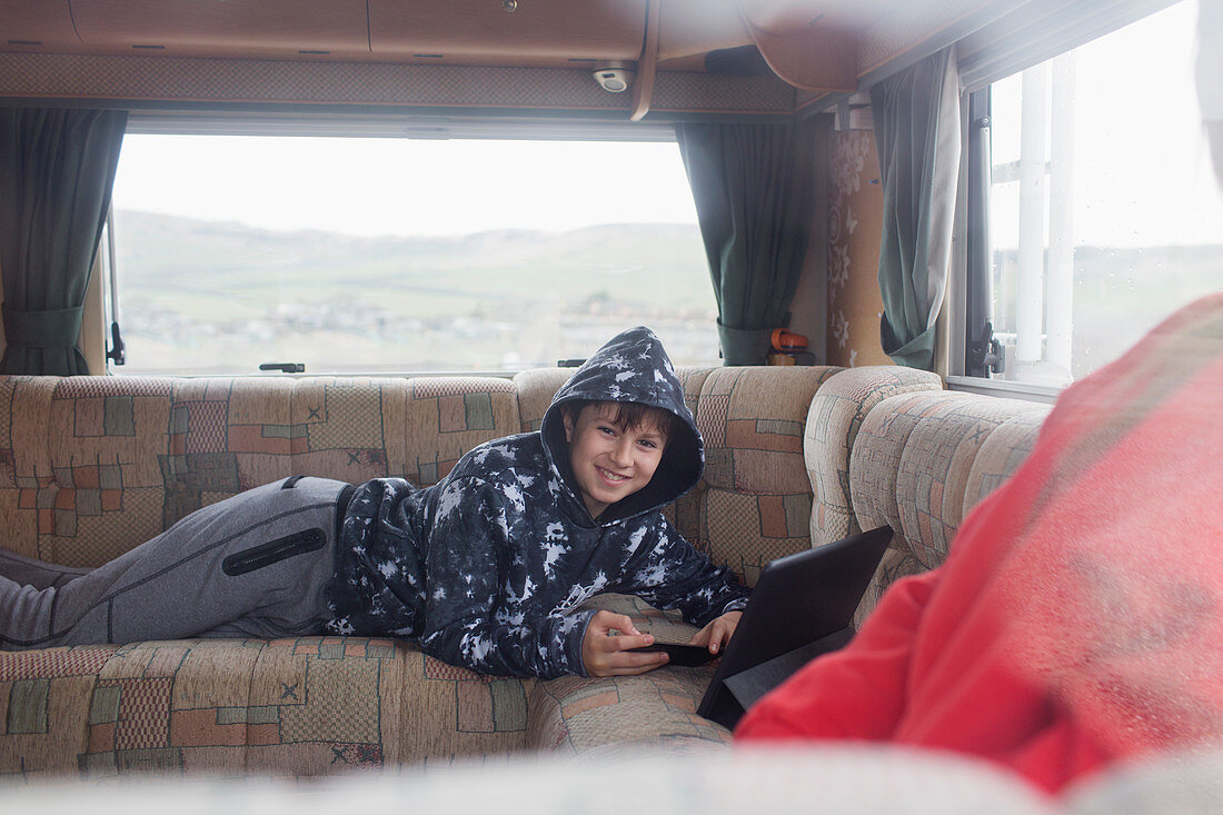 Portrait boy using digital tablet in motor home