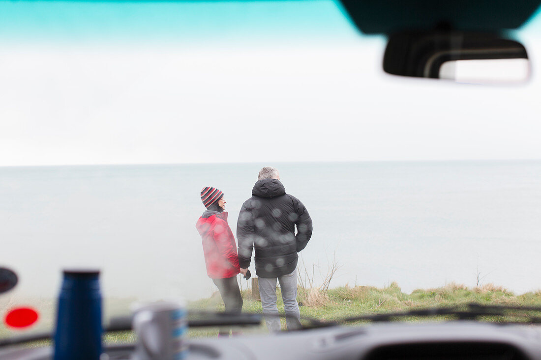Couple standing outside of motor home on cliff