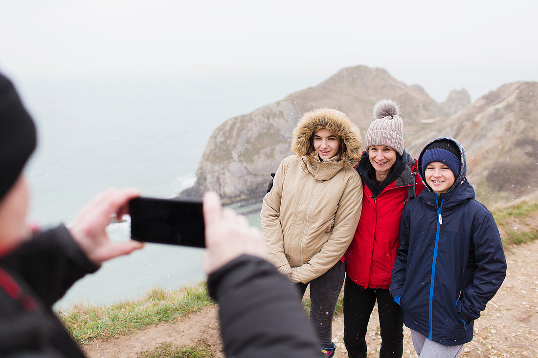Man photographing family on cliff