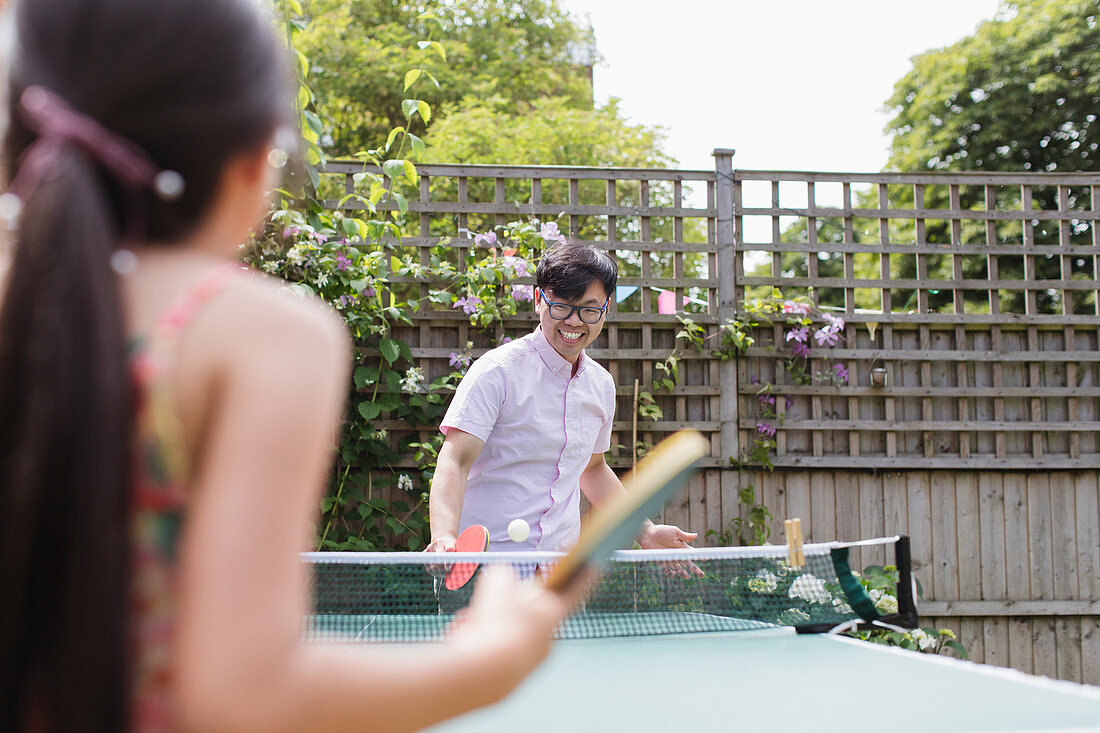 Father and daughter playing table tennis