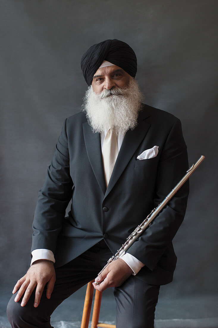 Portrait senior man in turban holding flute