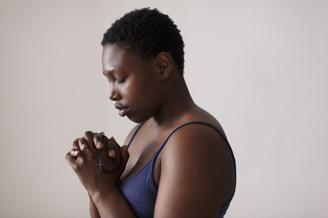 Portrait serene woman with rosary praying
