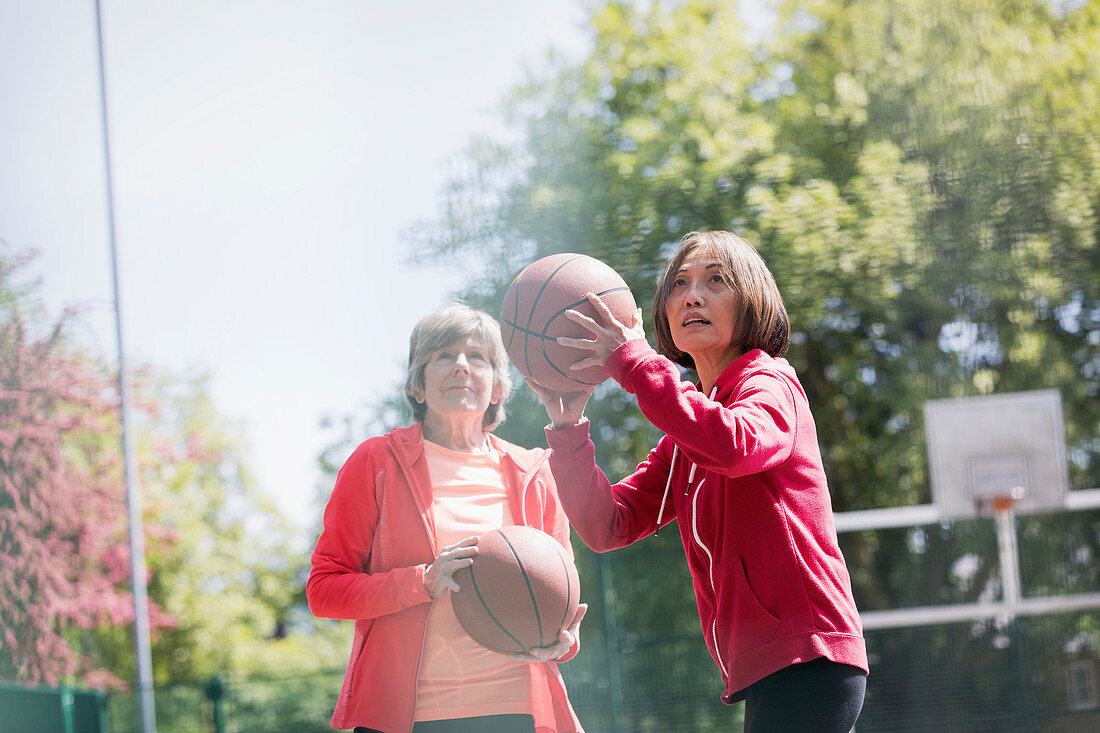 Active senior women friends playing basketball