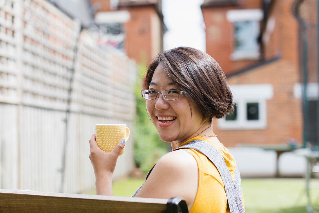 Portrait woman drinking tea in yard