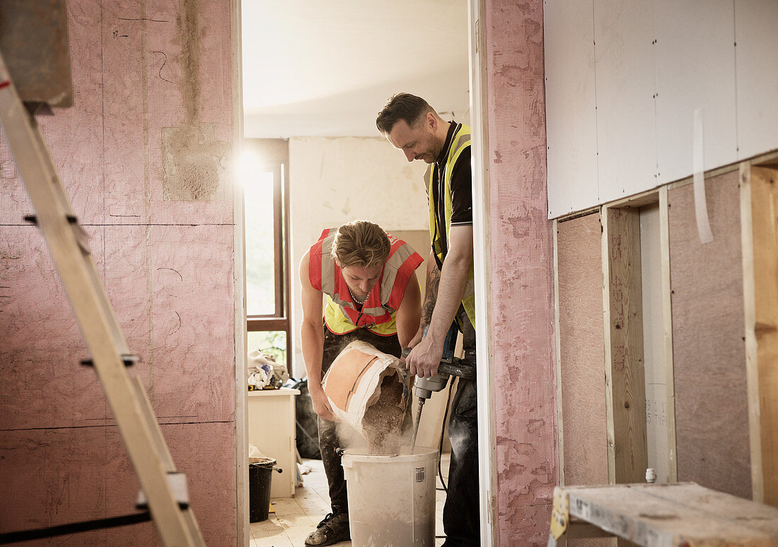 Construction workers mixing plaster in house
