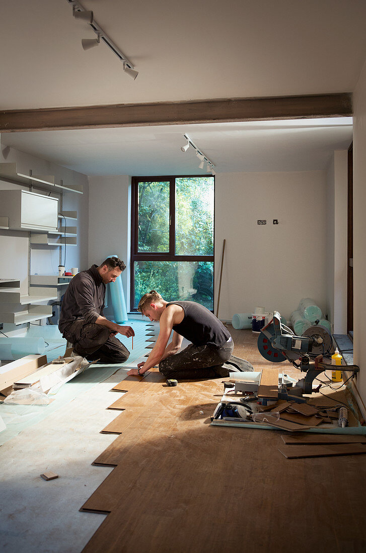 Construction workers laying hardwood flooring